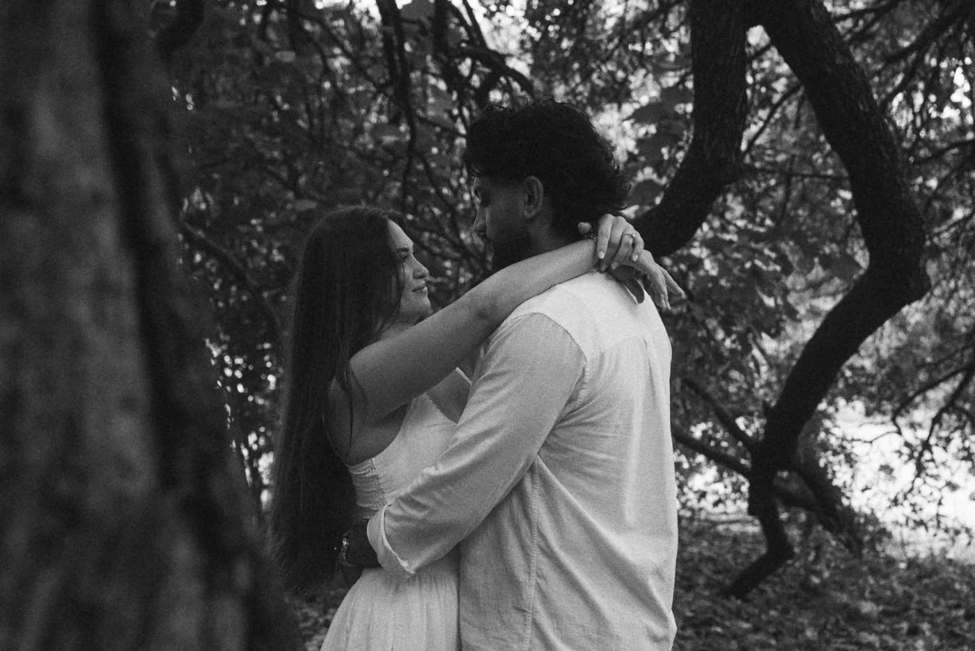 Harwant and Janelle embracing beneath the trees